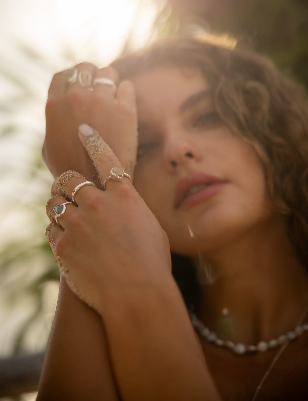 Woman wearing handcrafted Solspel rings in golden sunlight