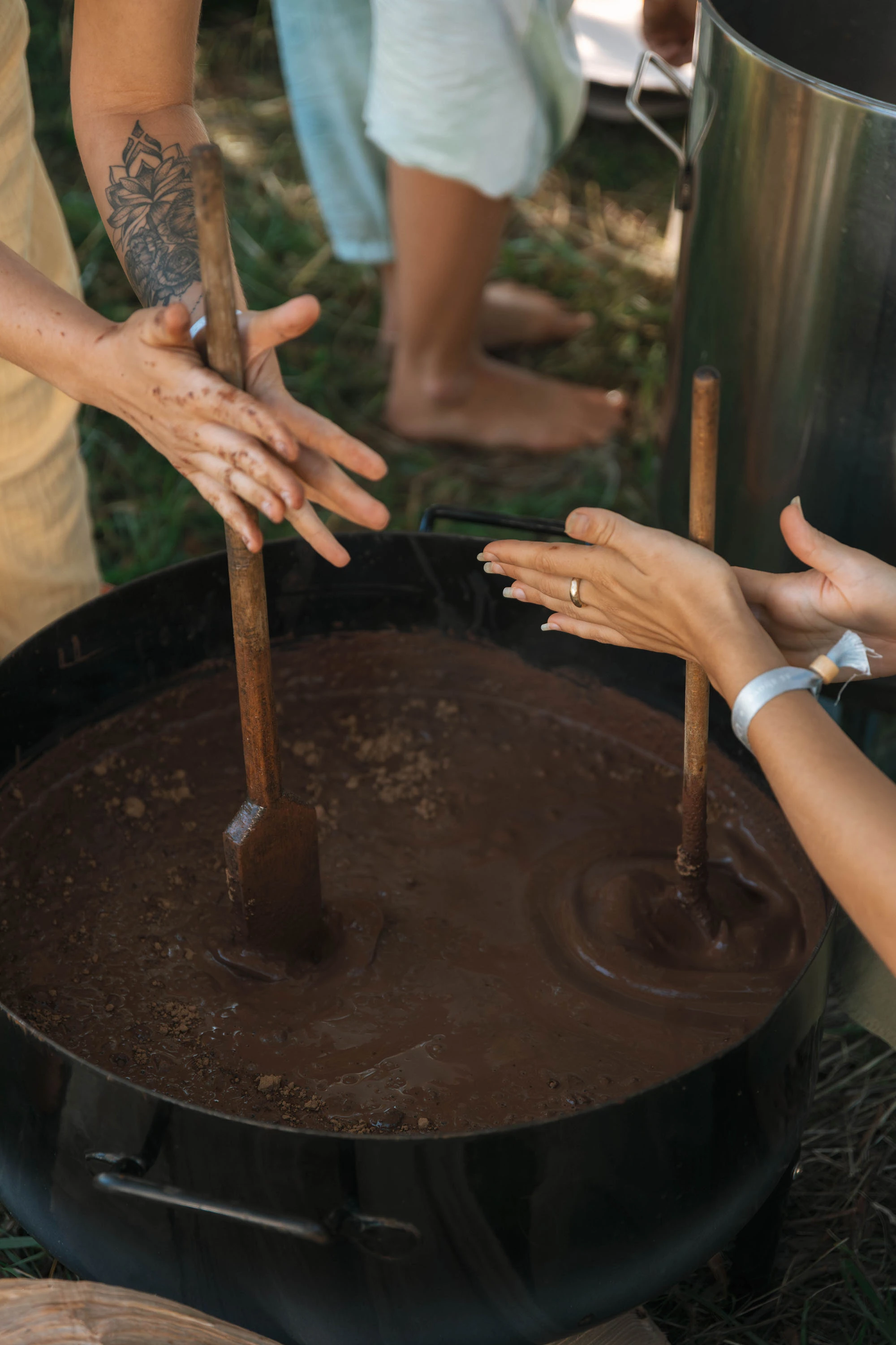 Hands preparing ceremonial cacao in a large pot